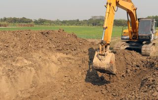 Excavator digging into dirt