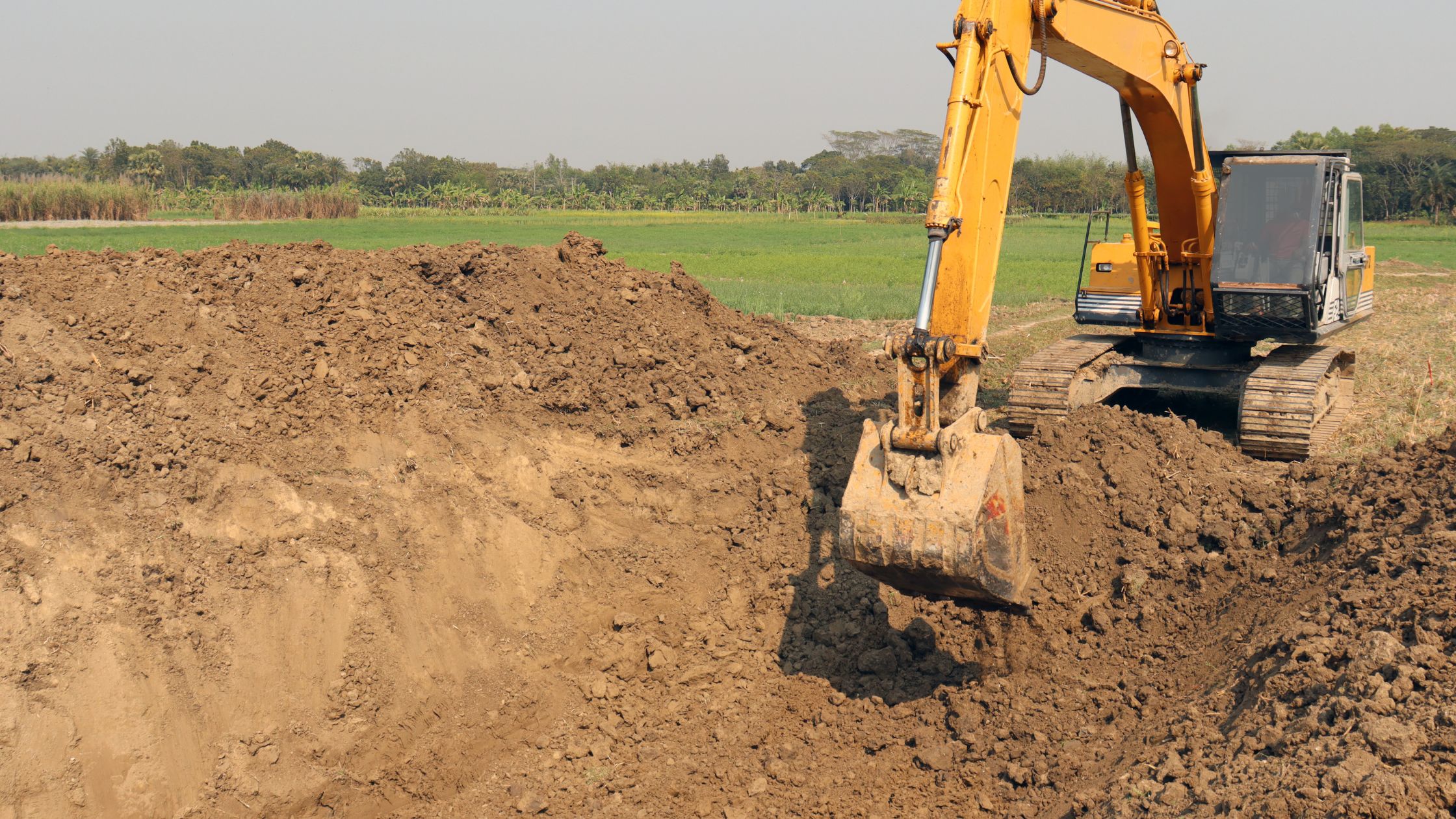 Excavator digging into dirt